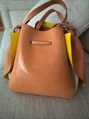 Classic Cognac Leather Shoulder Bag with Yellow Accent. Neutral linen.